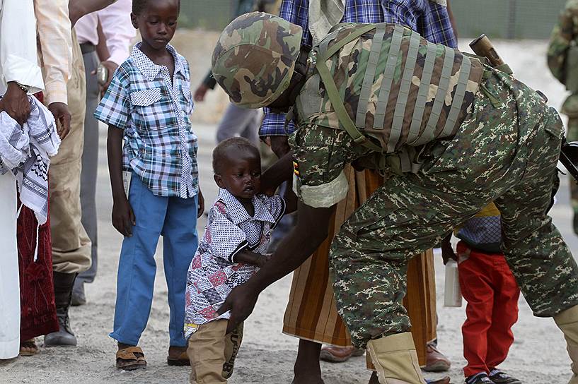 Солдат Миссии Африканского союза в Сомали (АМИСОМ) обыскивает ребенка на входе в мечеть в Могадишо