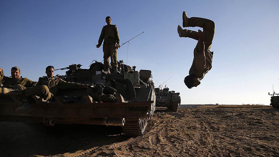 11.07.14. Израильский солдат делает сальто на фоне  бронетранспортера
