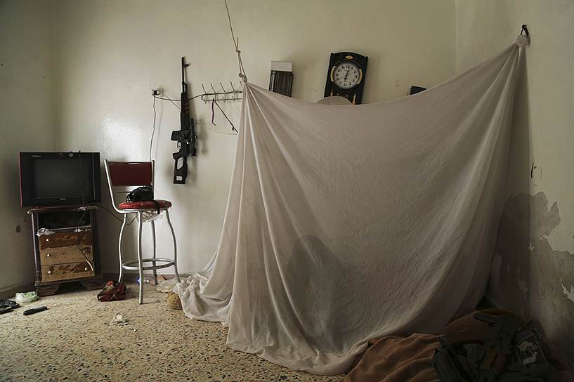 Сирийский повстанец отдыхает в одном из домов на линии фронта в Алеппо