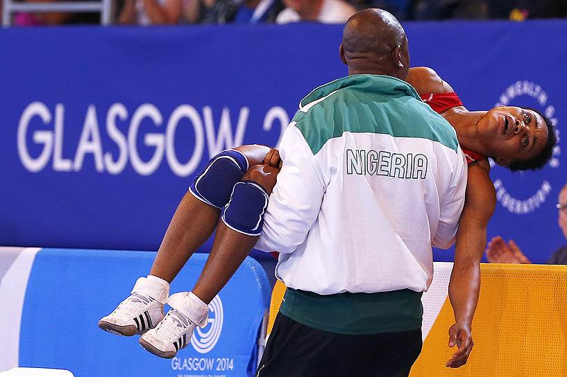 Тренер уносит нигерийскую спортсменку Ифеому Нвойе после проигрыша в полуфинале первенства по вольной борьбе в Глазго