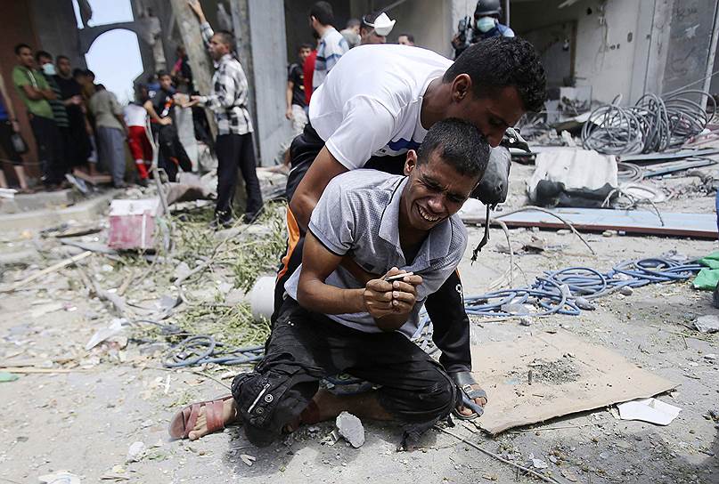 Палестинец, тело матери которого только что было извлечено из-под обломков дома, разрушенного, по словам очевидцев, в результате израильской воздушной атаки
