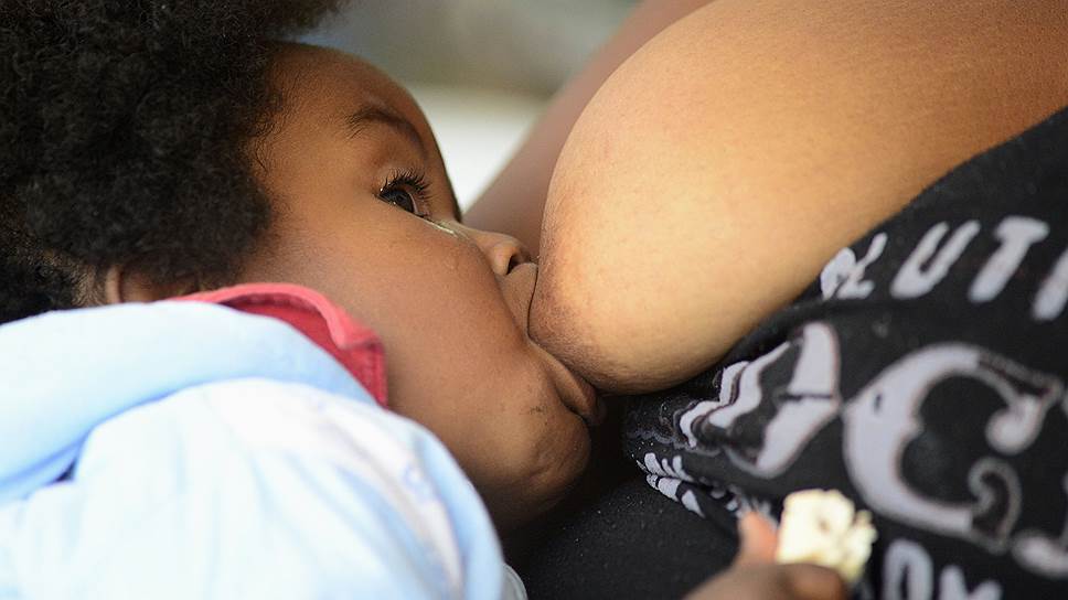 Женщина кормит ребенка в Карпуэле, Эквадор