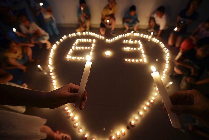 Дети молятся за пострадавших во время землетрясения в провинции Юньнань в Китае