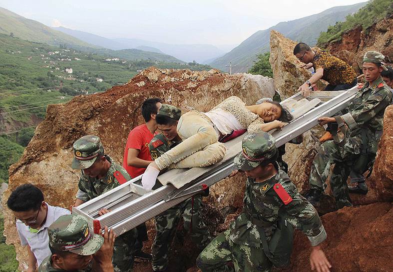Транспортировка раненой во время землетрясения женщины в китайской провинции Юньнань 