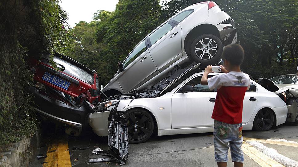 Мальчик фотографирует последствия автокатастрофы в провинции Гуандун в Китае