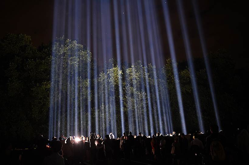 Люди наблюдают за инсталляцией «Spectra» на выставке «Lights Out» в Лондоне