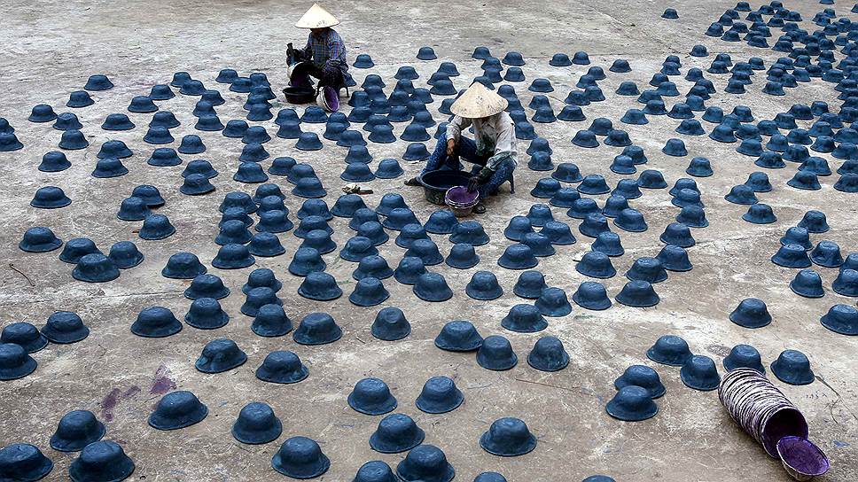 Работницы делают бумажные копии солдатских касок для фестиваля Vu Lan неподалеку от Ханоя (Вьетнам)