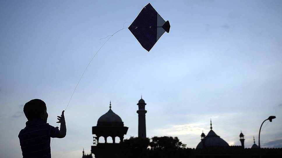 Мальчик запускает воздушного змея на фоне мечети Джама Масджид в старых кварталах Дели (Индия)