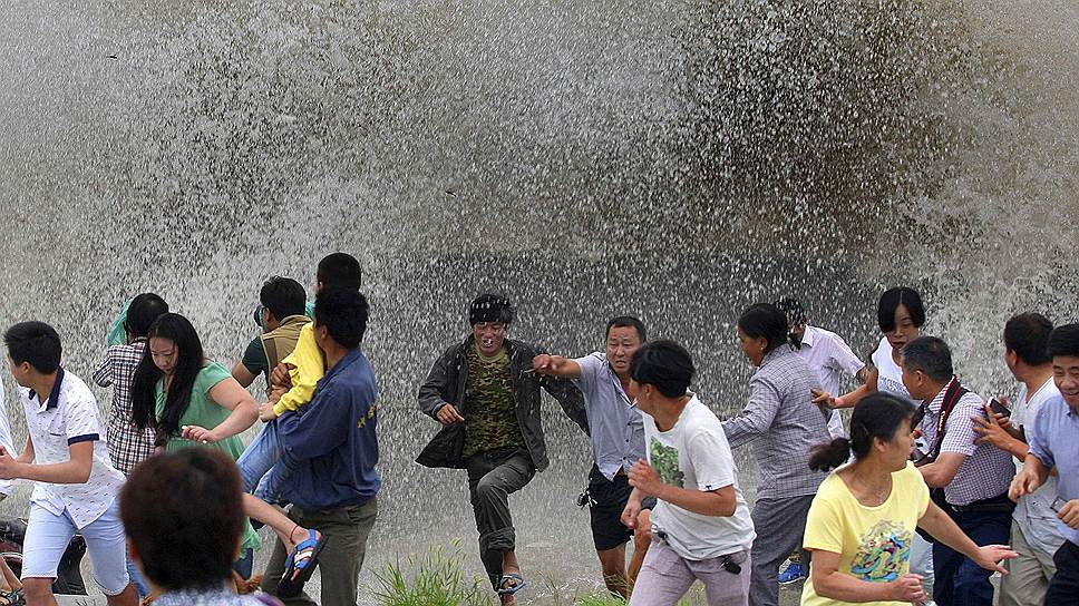 Люди бегут от приливной волны в Ханчжоу, китайская провинция Чжэцзян