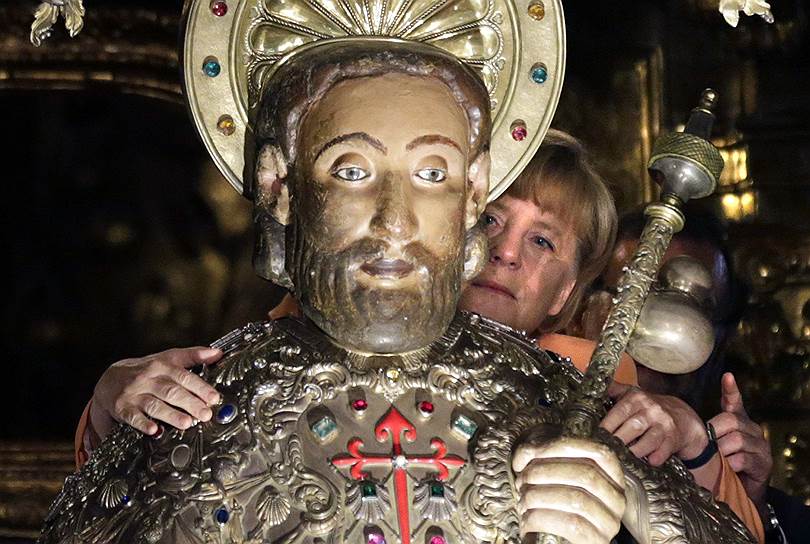 Канцлер Германии Ангела Меркель обнимает статую святого Иакова в кафедральном соборе в Сантьяго-де-Компостела, Испания