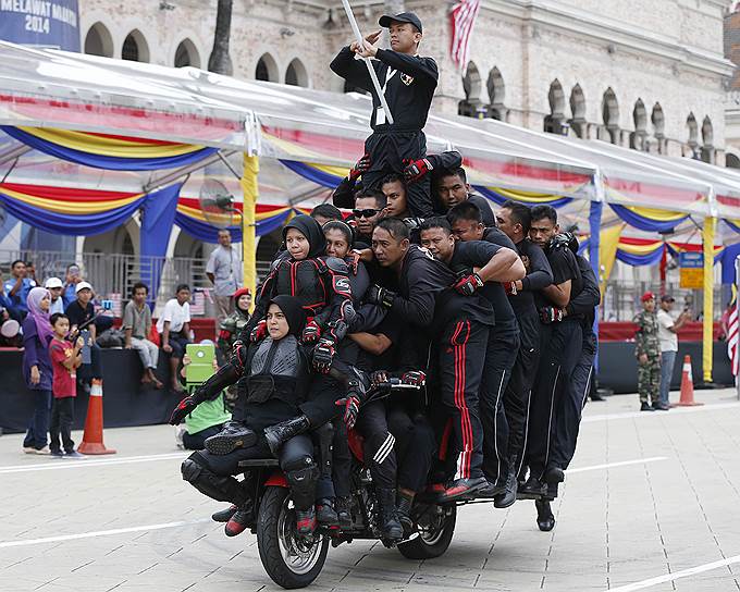 Группа из тридцати одного акробата балансирует на мотоцикле на репетиции парада в честь Дня независимости Малайзии в Куала-Лумпуре
