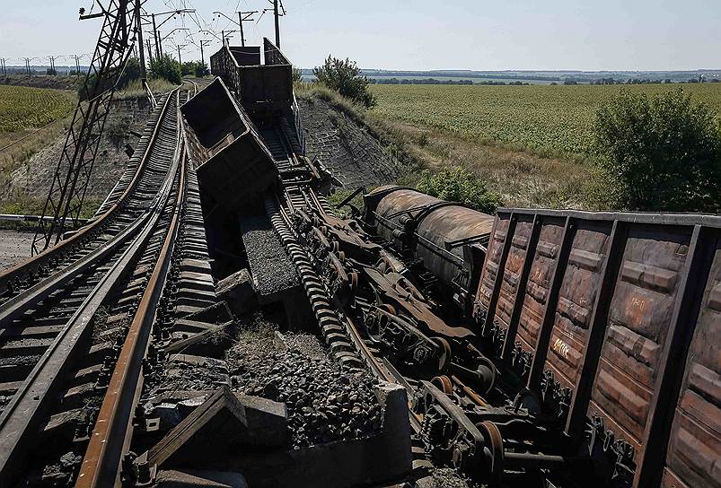 Вагоны грузового состава на разрушенном железнодорожном мосту в Донецкой области