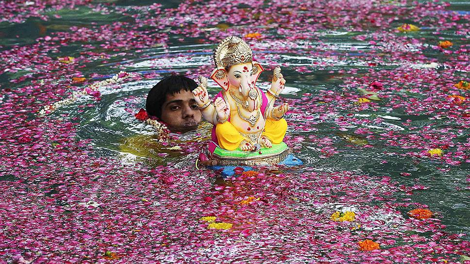 В последний день праздника тысячи людей собираются на пляжах Мумбая, чтобы совершить погружение святых идолов бога в море