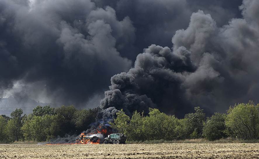 Военные машины, горящие после боя у села Березовое в Донецкой области
