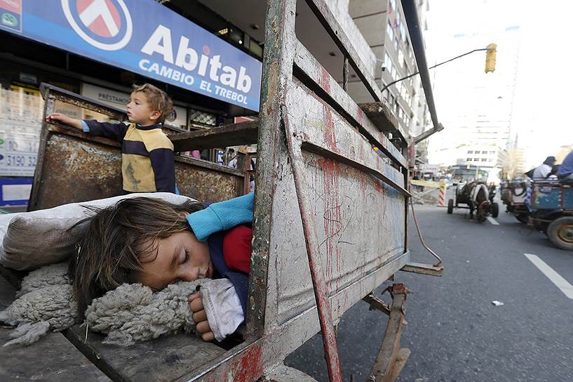 Дети спят в тележке, пока уборщики мусора устраивают демонстрацию у здания горсовета 