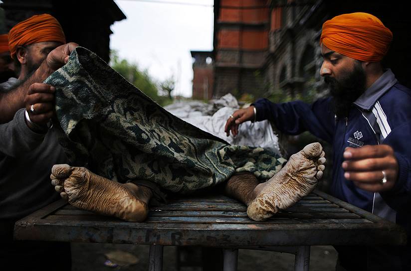 Кашмирские сикхи накрывают тело бизнесмена, погибшего при наводнении в Шринагаре