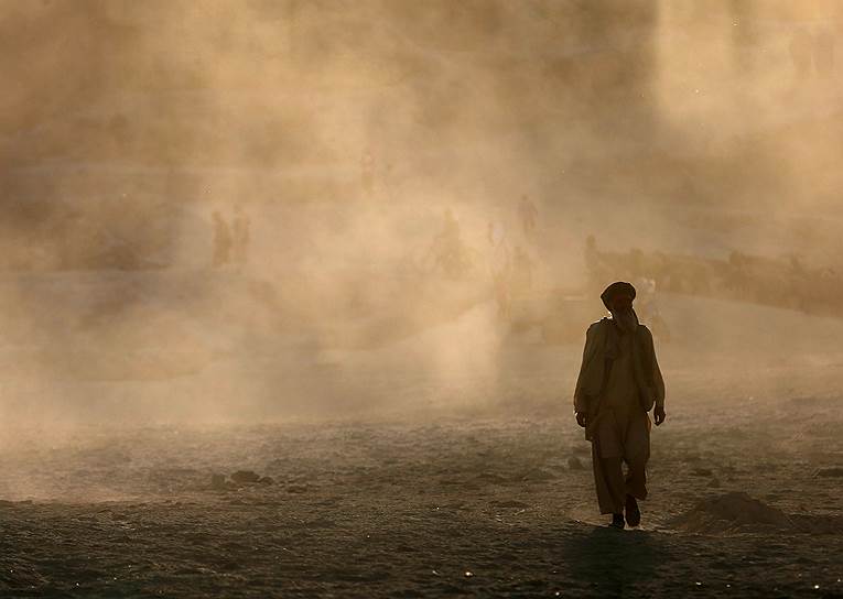 Афганец в облаке пыли в Кабуле