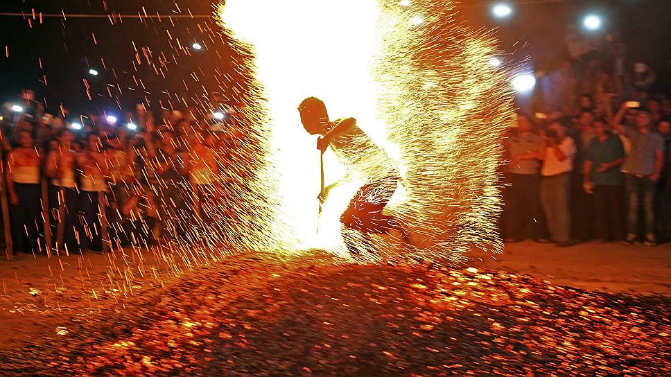 Китаец бежит босиком по углям во время традиционного ритуала «Ляньхо» в уезде Паньань, провинция Чжэцзян, Китай