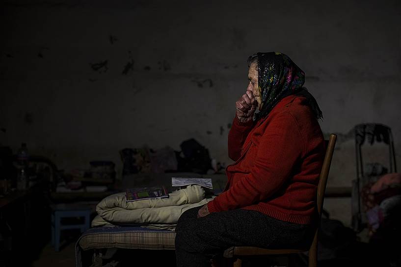 Пожилая женщина прячется от обстрелов в подвале дома в городе Ясиноватая Донецкой области