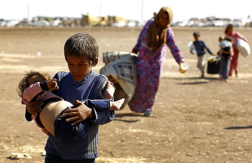 Сирийские курды, бегущие от «Исламского государства», после пересечения границы с Турцией в районе города Суруч