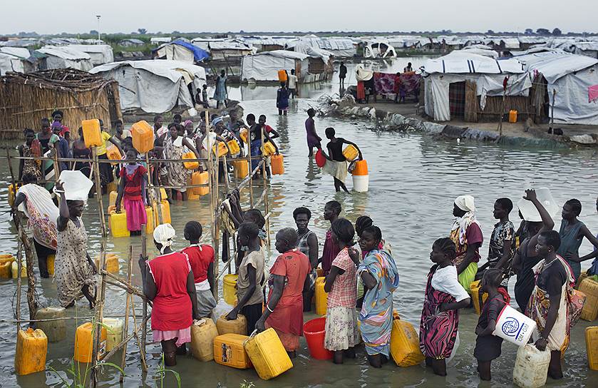 Бездомные Южного Судана стоят в очереди за питьевой водой в импровизированном лагере, организованном ООН, после потопа