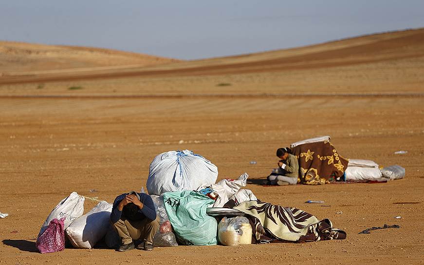 Сирийские курды со своими пожитками, бегущие от «Исламского государства», после пересечения границы с Турцией в районе города Суруч
