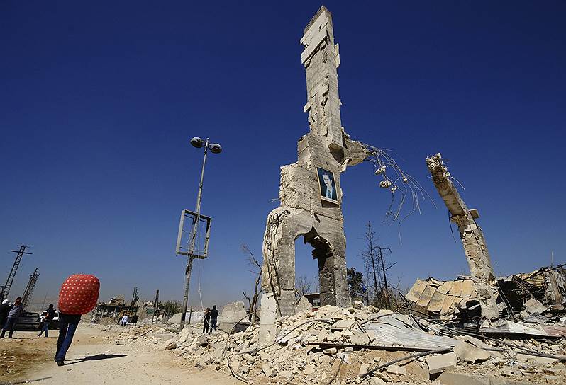 Портрет президента Сирии Башара Асада на разрушенном строении в пригороде Дамаска