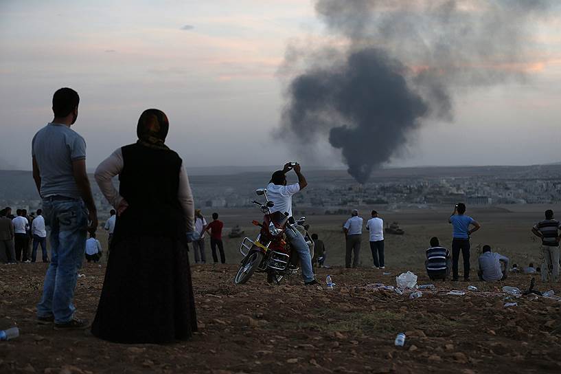 Турецкие курды наблюдают за пожарами в сирийском приграничном городе Кобани после ударов по позициям боевиков «Исламского государства»