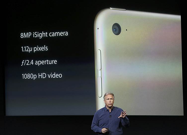 Новая 8-мегапиксельная камера iSight будет установлена в iPad Air, позволяя записывать видеоролики и панорамы с разрешением 43 мегапикселя. Камера iPad Mini сохранила камеру мощностью в 5 мегапикселей&lt;br> На фото: старший вице-президент по маркетингу компании Apple Филипп Шиллер демонстрирует обновленную камеру iPad Air