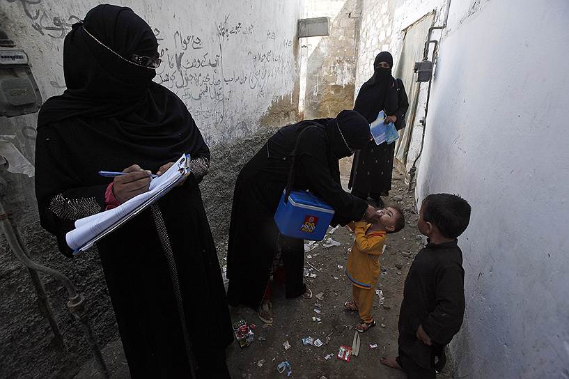 Врачи, прививающие детей от полиомелита в трущобном районе Карачи, Пакистан