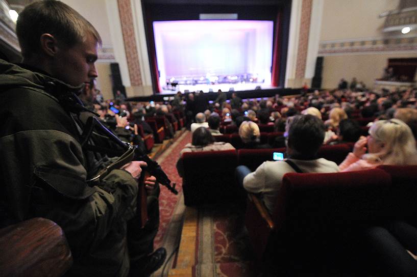Ополченец в зрительном зале в оперном театре Донецка перед началом концерта Иосифа Кобзона