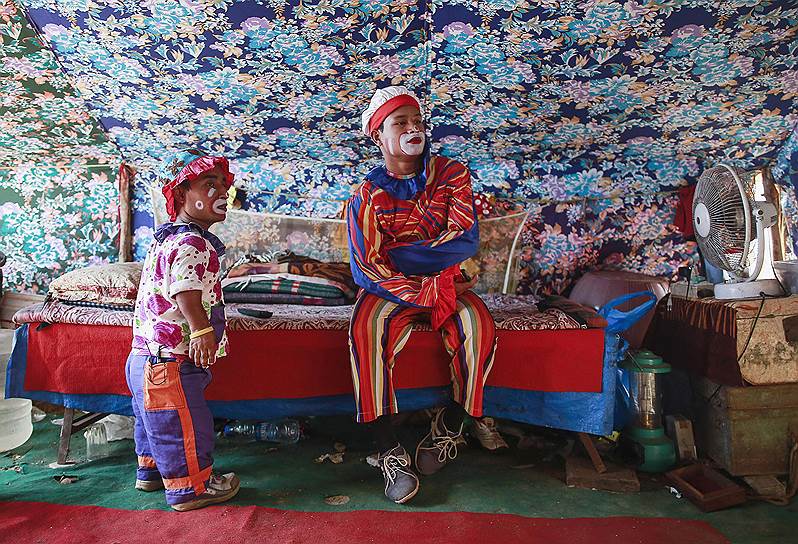 Мумбаи, Индия. Цирковые клоуны смотрят телевизор перед выступлением