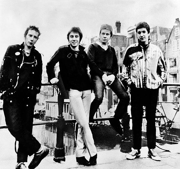 История Sex Pistols началась в середине 1970-х, когда у начинающего музыкального продюсера Малкольма Макларена возникла идея создать провокационную рок-группу. На тот момент Макларен был больше известен как модельер и совладелец культового лондонского магазина одежды на Кингс-роуд, который он открыл со своей девушкой Вивьен Вествуд в 1971 году. Группе The Strand, менеджером которой Макларен уже являлся, не хватало харизматичного вокалиста
&lt;br>На фото слева направо: Джонни Роттен, Глен Матлок, Пол Кук и Стив Джонс
