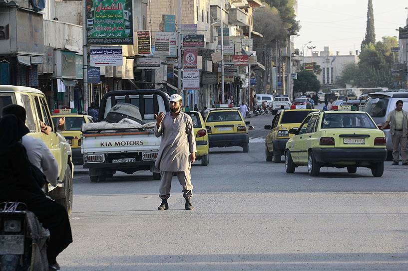 Сотрудник полиции «Исламского государства» регулирует движение на улице в Ракке