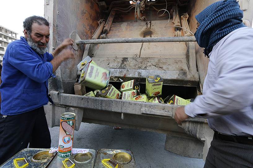 Люди, нанятые «Исламским государством» для контроля качества продуктов, выбрасывают некондиционные товары, конфискованные из магазинов