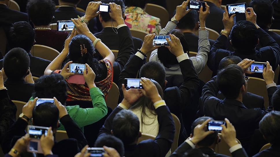 Пекин, Китай. Делегаты АТЭС снимают президента России Владимира Путина на смартфоны во время его речи в Пекинском международном конференц-центре