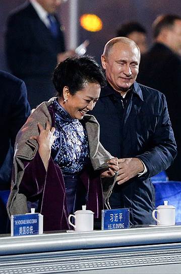 Президент России Владимир Путин набрасывает шаль на плечи первой леди Китая Пэн Лиюань