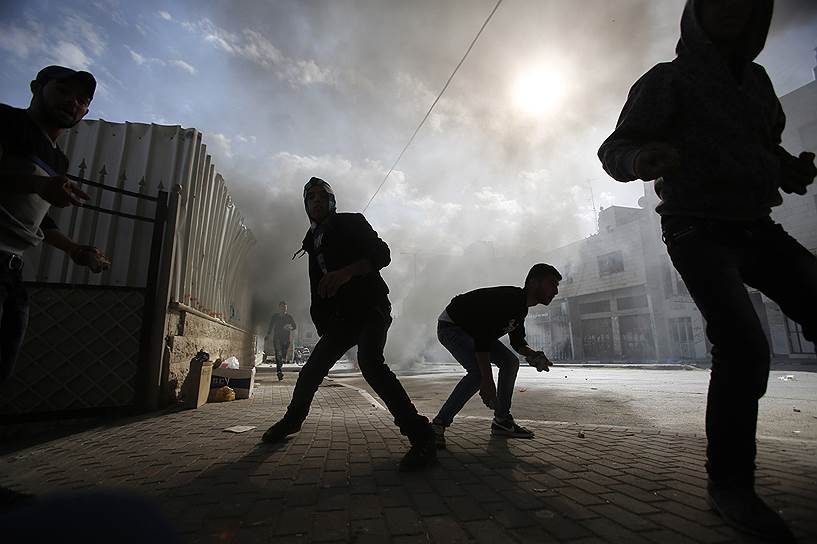 Хеврон, Западный берег реки Иордан. Палестинские протестующие готовятся бросать камни  в солдат армии Израиля во время столкновений, последовавших за антиизраильской демонстрацией 