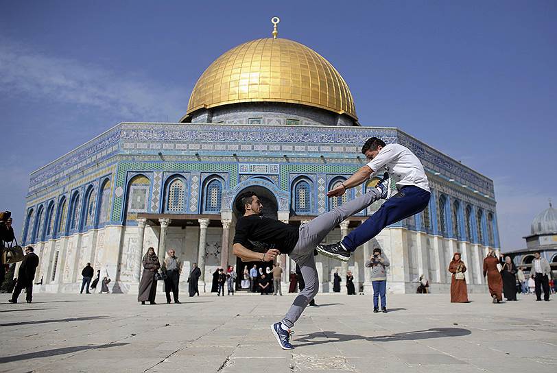 Иерусалим, Израиль. Палестинские подростки занимаются паркуром на фоне Купола Скалы во время пятничной молитвы  