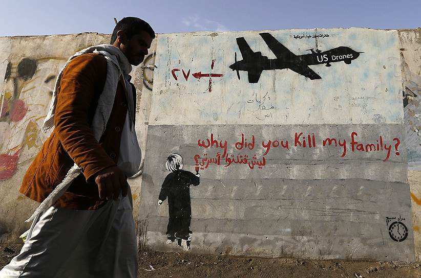 Сана, Йемен. Человек проходит мимо стены, на которой нарисованы граффити, осуждающие бомбардировки, проводимые американскими беспилотниками   