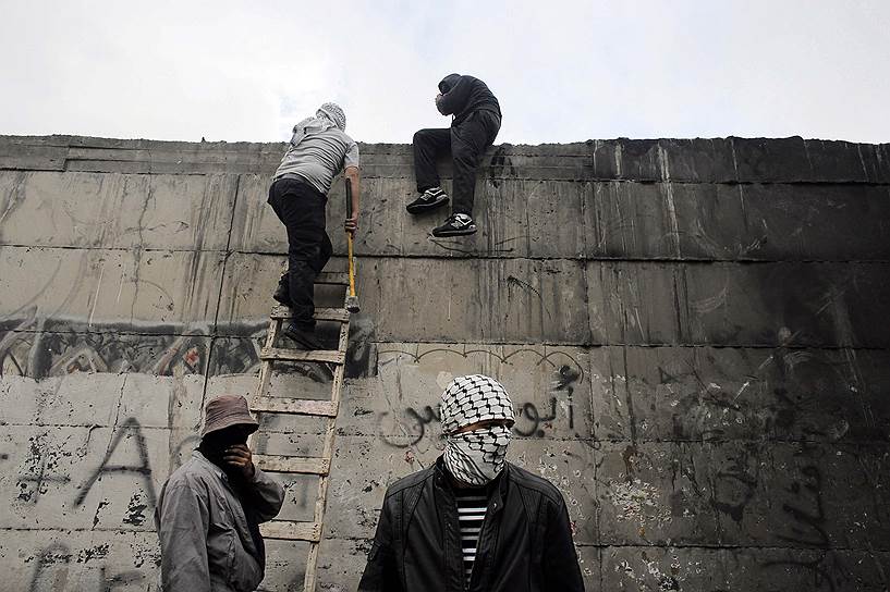 Абу-Дис, Палестина. Демонстранты залезают на стену, отделяющую город от Иерусалима