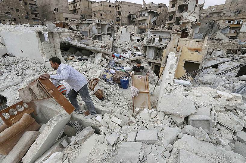 Алеппо, Сирия. Местные жители ищут вещи, уцелевшие под обломками зданий