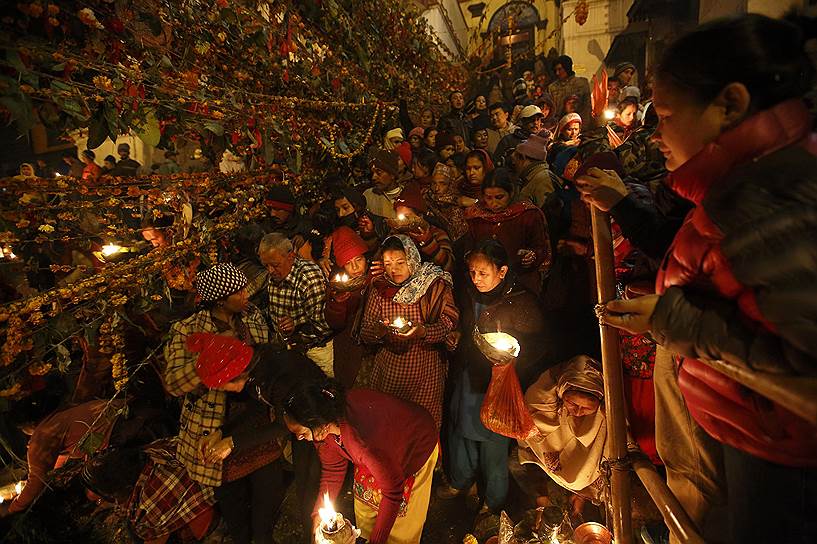Катманду, Непал. Верующие с масляными лампами во время ритуала во время религиозного фестиваля Бала Чатурдаши