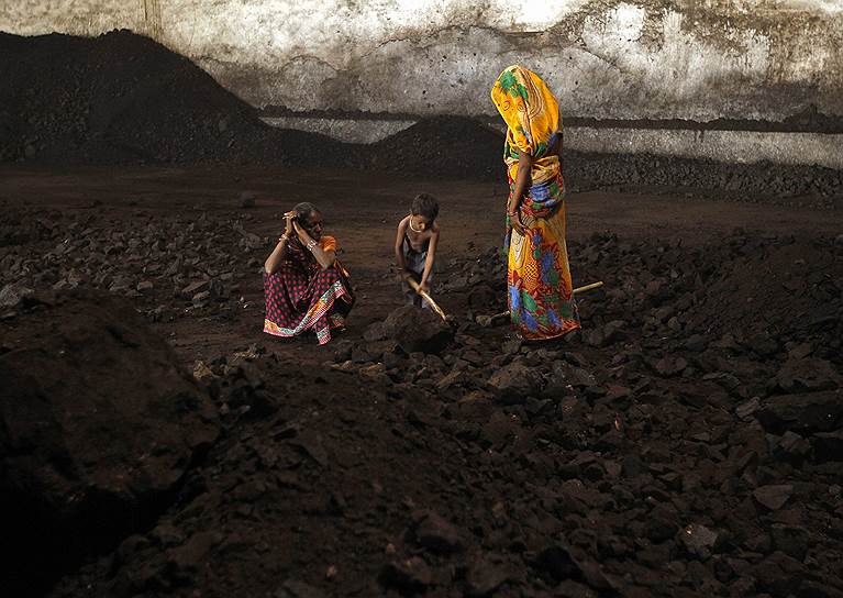 Ахмедабад, Индия. Женщины и мальчик, играющийся с лопатой и углем