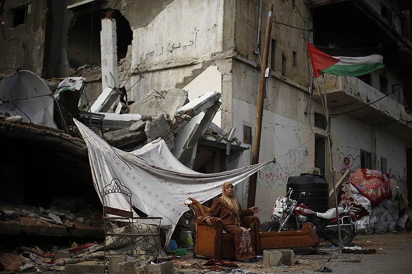 Газа, Палестина. Палестинка сидит на диване возле своего дома, который, по словам свидетелей, был разрушен в результате израильского обстрела во время последнего столкновения между Израилем и ХАМАС