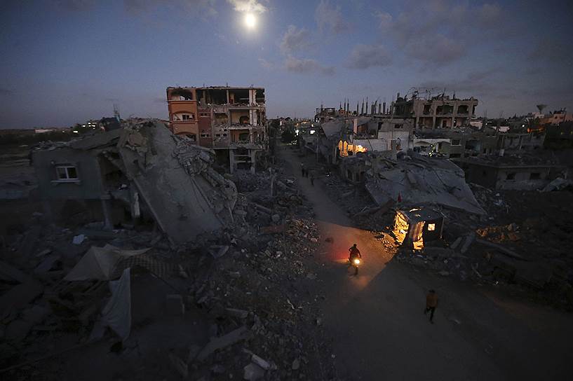 Руины города в Газе, разрушенного в ходе израильского наступления
&lt;br>Мухаммад Салем: «Я снимал дома, который были разрушены во время 51-дневной войны в Газе. Я передвигался от одного разрушенного дома к другому, видел людей, сидящих в убежищах. Мое внимание привлек мотоциклист. Непросто было сделать фото, так как света почти не было. Но мне повезло — фары автомобиля осветили мотоцикл»  