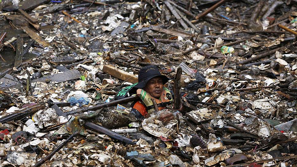 Джакарта, Индонезия. Волонтер во время уборки акватории реки Силивунг от мусора