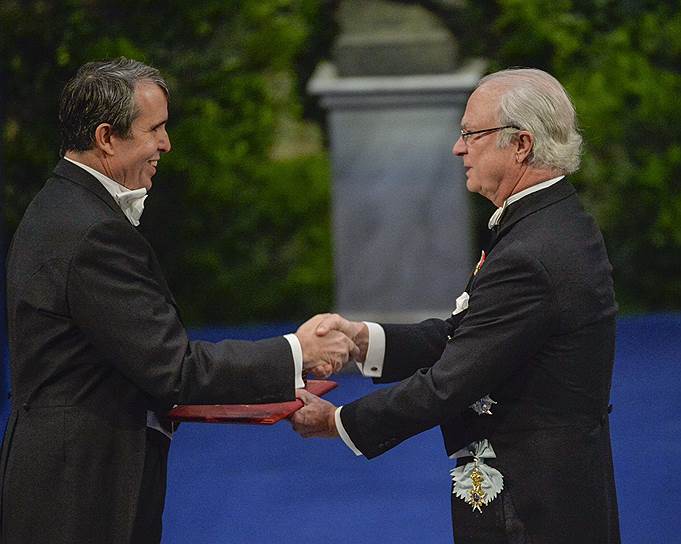 Лауреат Нобелевской премии-2014 по химии Эрик Бетциг (слева) получает награду из рук короля Швеции Карла XVI Густафа