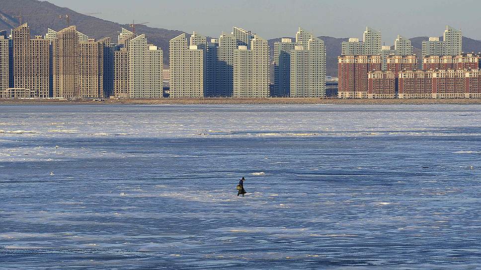 Далянь, провинция Ляонин, Китай. Рыбак на льду Бохайского залива