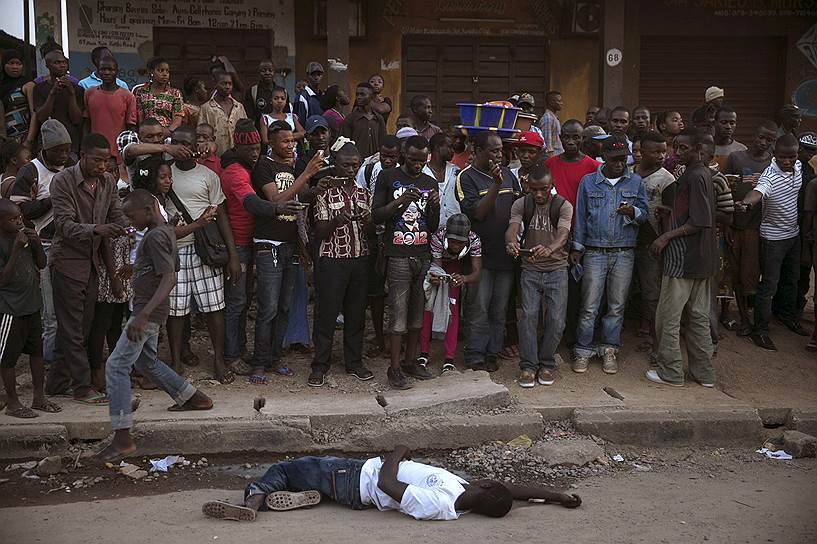 Койду, Сьерра-Леоне. Тело местного жителя, предположительно погибшего от лихорадки Эбола, на улице города